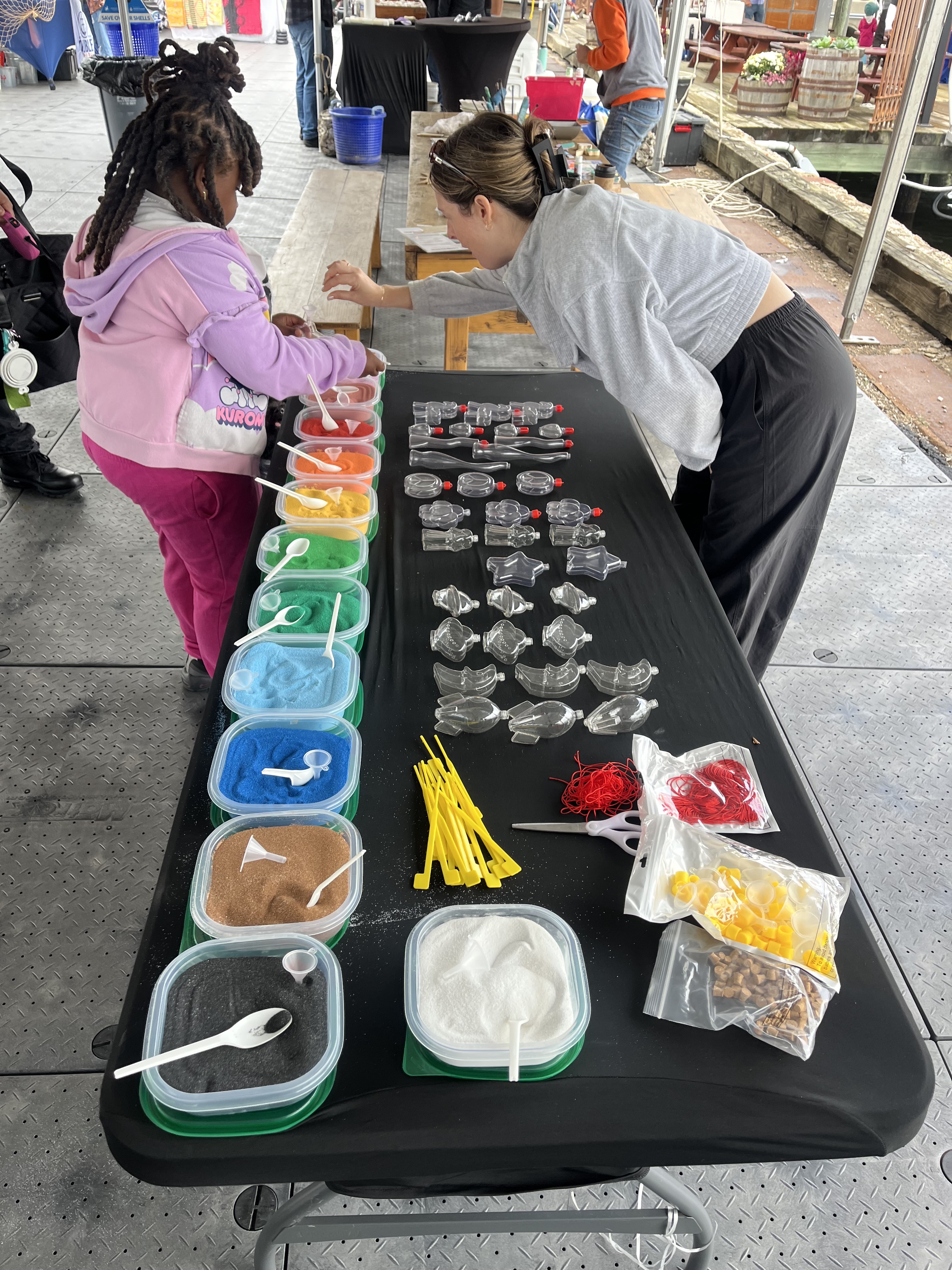 Girl and woman participating in sand art craft party corporate event
